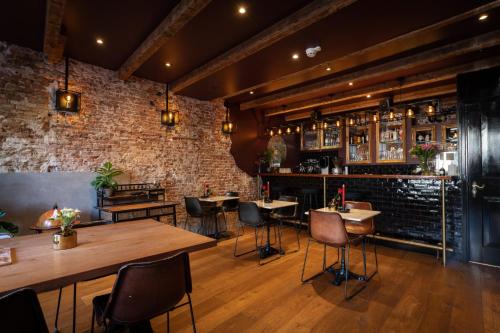 a restaurant with tables and chairs and a brick wall at Hotel Hoksbergen in Amsterdam