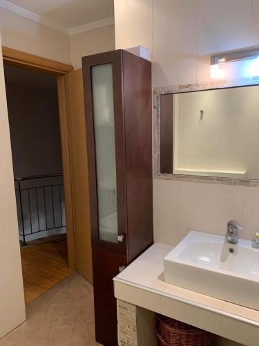 La salle de bains est pourvue d'un lavabo et d'un miroir. dans l'établissement Two Floor Luxurious Villa #skg, à Thessalonique