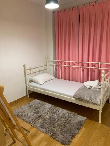 łóżko w pokoju z różową zasłoną w obiekcie Two Floor Luxurious Villa #skg w Salonikach