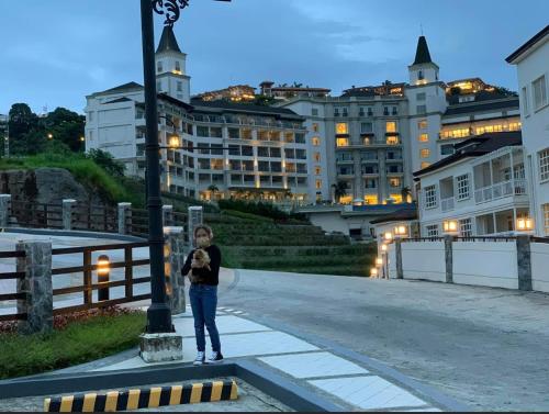 a woman standing on a street with a dog at Twin lakes Merlot LL3-F in Tagaytay