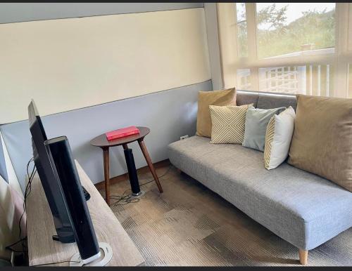 a living room with a couch and a flat screen tv at Twin lakes Merlot LL3-F in Tagaytay