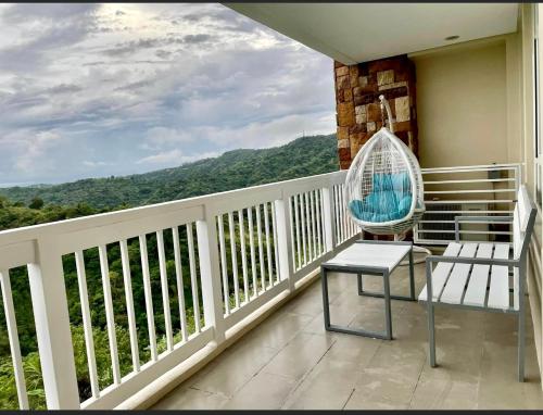 uma varanda com uma cadeira e vista para as montanhas em Twin lakes Merlot LL3-F em Tagaytay