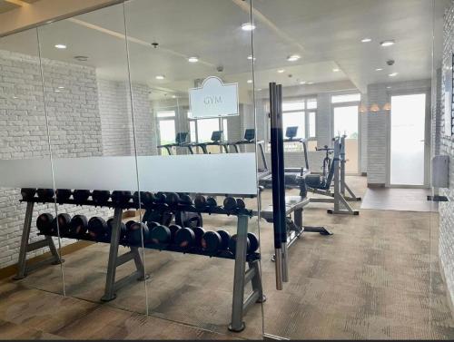 a gym with a row of exercise equipment and a mirror at Twin lakes Merlot LL3-F in Tagaytay