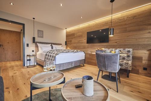 um quarto de hotel com uma cama, uma mesa e cadeiras em Chalet Alpenruhe em Oberstaufen