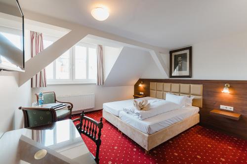 a bedroom with a bed and a desk in it at Hotel Alt Görlitz in Görlitz