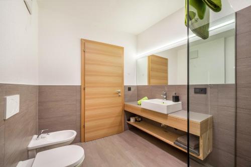 a bathroom with a sink and a toilet and a mirror at Residence Kalchgruberhof Fichte in Ultimo