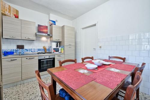 a kitchen with a wooden table with a red table cloth at R&R Apartment in Marghera