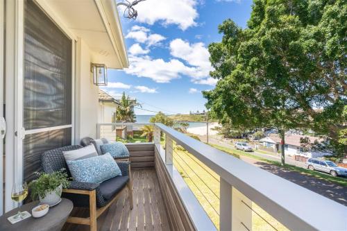 a balcony with chairs and a view of the ocean at 8 on Chapman in Kiama