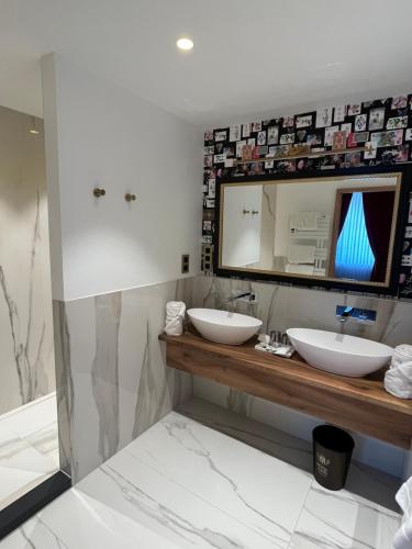 a bathroom with two sinks and a mirror at Hôtel du Domaine de La Grange de Condé in Condé-Northen