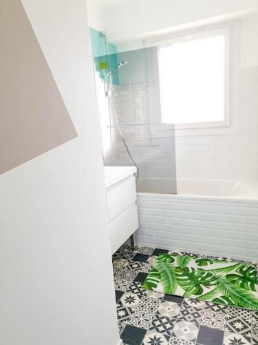 La salle de bains est pourvue d'une baignoire et d'une plante. dans l'établissement Cosy Summer 2CH - Parc Expo - 2 Balcons & stationnement gratuit, à Pau