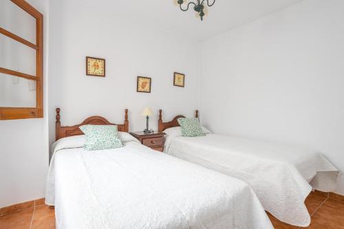 two beds in a room with white walls at Apartment Nieves 2 in Nerja