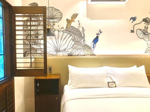 a bedroom with a bed and a wall with drawings at The Henry Hotel Roost Bacolod in Bacolod