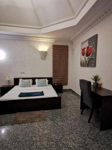 a bedroom with a bed and a desk and a desk sidx sidx sidx at L'Address in Cotonou