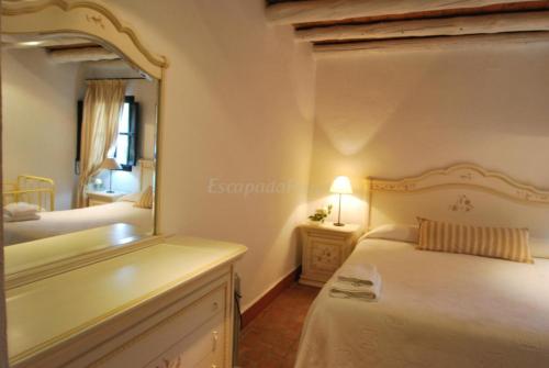 a bedroom with a bed with a mirror and a sink at Finca La Vicacaria LIMONERO in Zufre