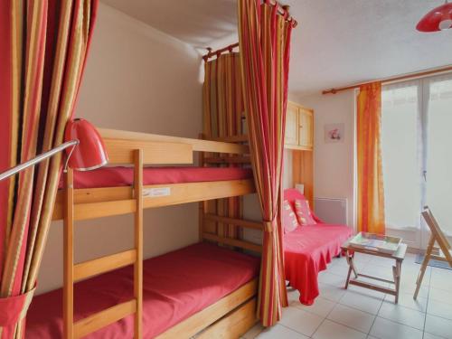une chambre avec deux lits superposés et un canapé dans l'établissement Studio cosy avec jardin et parking près des stations de ski, quartier calme Exposition Sud-Ouest - FR-1-402-81, à Esquièze - Sère