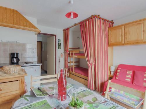 une cuisine avec une table et un rideau rouge dans l'établissement Studio cosy avec jardin et parking près des stations de ski, quartier calme Exposition Sud-Ouest - FR-1-402-81, à Esquièze - Sère