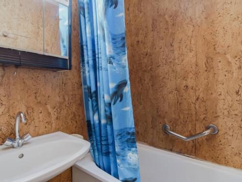 une salle de bain avec un lavabo et un rideau de douche dans l'établissement Studio cosy avec jardin et parking près des stations de ski, quartier calme Exposition Sud-Ouest - FR-1-402-81, à Esquièze - Sère