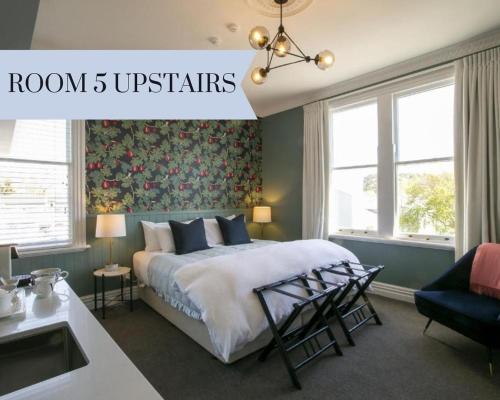 a bedroom with a bed and a sink and windows at The Vicarage Geraldine in Geraldine