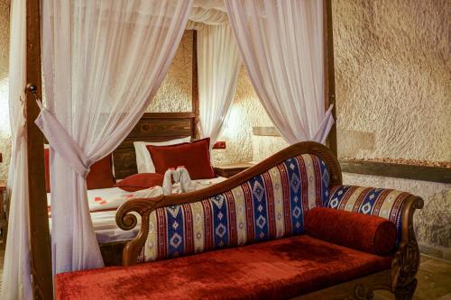 a bedroom with a couch in front of a bed at Efendi Cave Hotel in Ürgüp