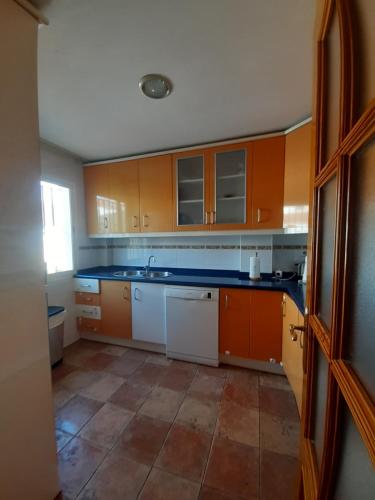 cocina con armarios de color naranja y suelo de baldosa en Oasis de paz en el Campo de Gibraltar, en Los Barrios