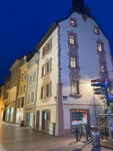 un bâtiment avec une tour d'horloge dans une rue la nuit dans l'établissement Gîte des Victoires, à Mulhouse