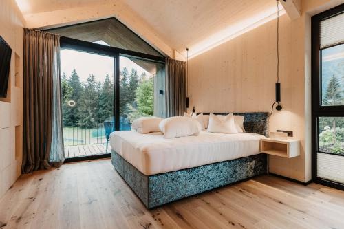 um quarto com uma cama grande e uma janela grande em Almliesl UNKE-684 em Unken