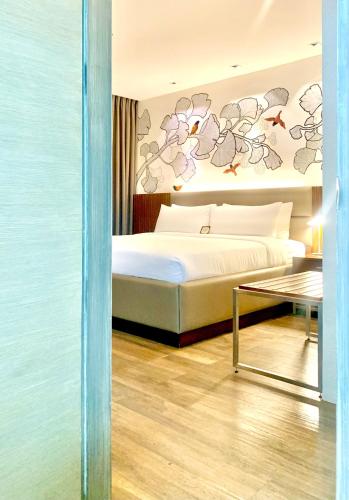 a bedroom with a bed and a table at The Henry Hotel Roost Bacolod in Bacolod