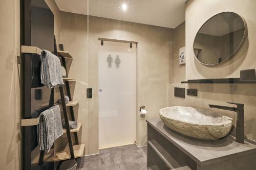 ein Badezimmer mit einem großen Steinwaschbecken und einem Spiegel in der Unterkunft Chalet Hirschgold in Oberstaufen