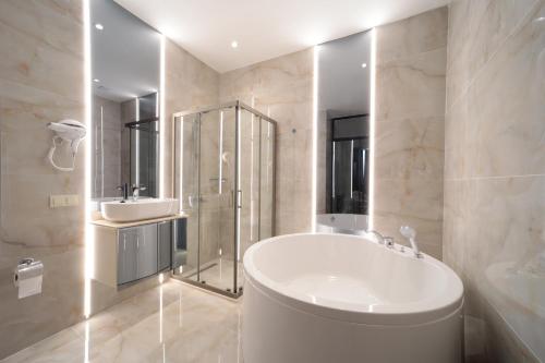 a white bathroom with a tub and a sink at Gatto Suites&Residence in Istanbul