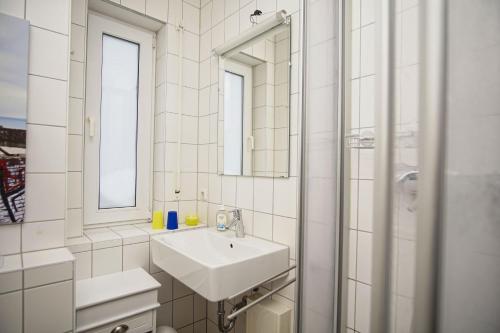 a white bathroom with a sink and a mirror at gemütliche Ferienwohnung in Hafennähe - FeWos am Hochzeitsberg FeWo 08 in Breege