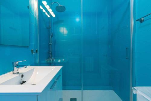 uma casa de banho com um lavatório e uma cabina de duche em vidro. em Confortable piso 3 habitaciones en Retiro Atocha em Madri