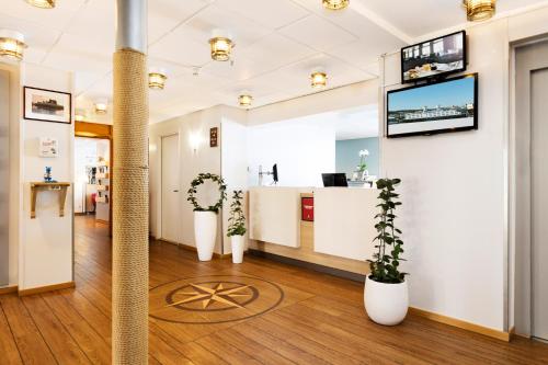 an office with potted plants and a tv on a wall at Good Morning+ Göteborg City in Gothenburg
