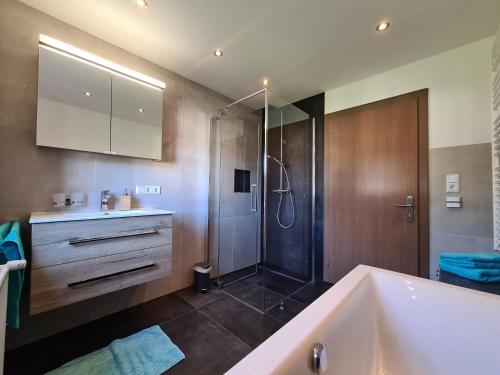 La salle de bains est pourvue d'une baignoire et d'une douche. dans l'établissement Ferienwohnung Scharf, à Reutte