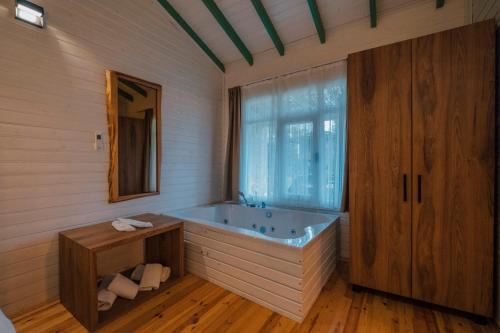 ein Bad mit einer Badewanne und einem Fenster in der Unterkunft SAPANCA BAMBOOLOW RESORT in Sakarya