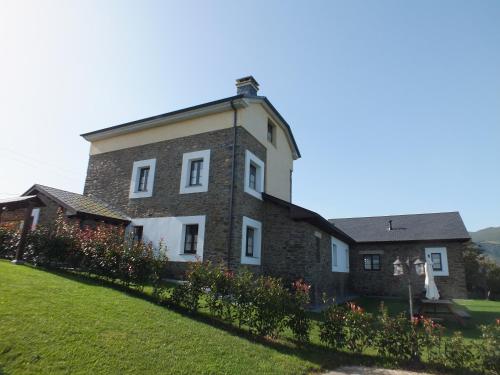a large brick building with flowers in front of it at Apartamentos Puerta del Castro in Coaña