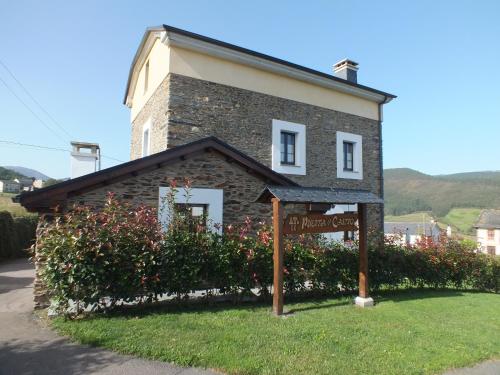 a small brick building with a sign in front of it at Apartamentos Puerta del Castro in Coaña