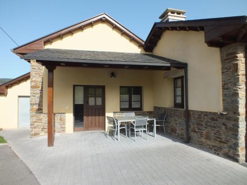 a patio with a table and chairs in front of a house at Apartamentos Puerta del Castro in Coaña