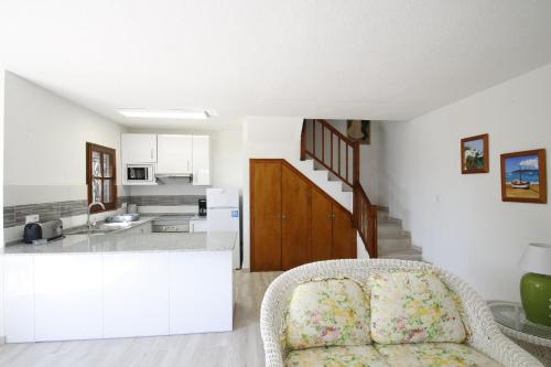 sala de estar con silla y cocina en Casas Blancas 39, en Miami Platja