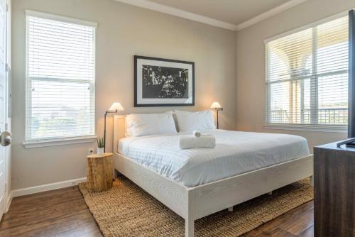 a bedroom with a white bed and two windows at Bright and Spacious Apartments with Gym and Pool Access at Century Stone Hill North in Pflugerville, Austin in Pflugerville