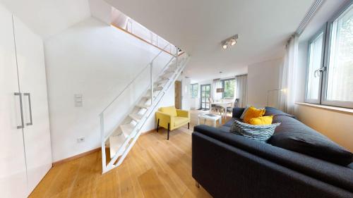 a living room with a black couch and a staircase at Ankerhaus Ankerhaus 4 in Hörnum