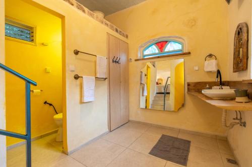 La salle de bains est pourvue d'un lavabo, de toilettes et d'une fenêtre. dans l'établissement הפינה שלה -Hapina shella ראש פינה העתיקה, à Rosh Pinna