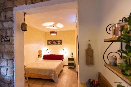een slaapkamer met een bed met een rode deken bij הפינה שלה -Hapina shella ראש פינה העתיקה in Rosh Pinna
