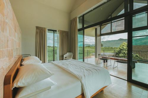 a bedroom with a large bed and a balcony at twoDO KhaoYai in Mu Si