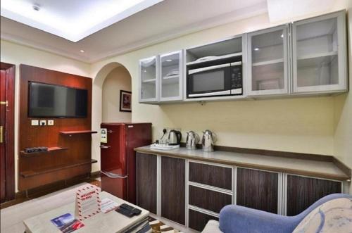 a kitchen with a counter and a microwave and a refrigerator at قصر اليمامة للشقق المخدومة Al Yamama Palace Serviced Apartments in Yanbu