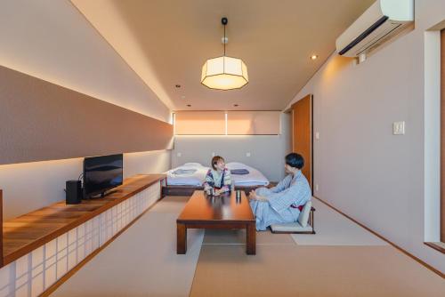 two children sitting in a room with a bed at SEKIYA RESORT Terrace Midoubaru in Beppu