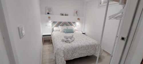 una piccola camera da letto con un letto con un animale di peluche di Apartamentos Centro Confor 3 a Quesada