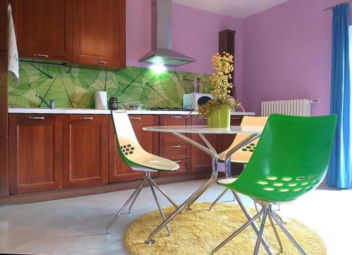 een keuken met een tafel en twee groene stoelen bij LA CASA DI GILINDO in Roccabruna