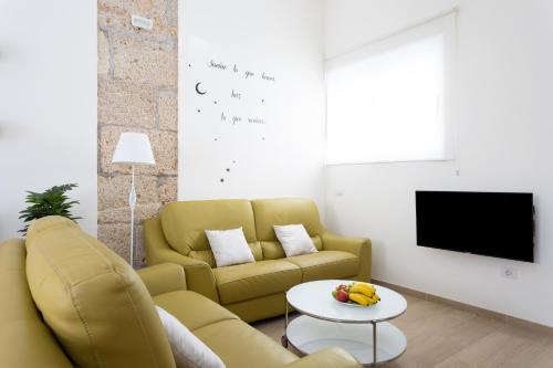 ein Wohnzimmer mit einem gelben Sofa und einem Tisch in der Unterkunft Home2Book La Casita del Mercado in Santa Cruz de Tenerife