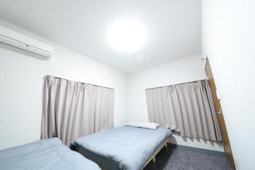 een slaapkamer met 2 bedden en een raam bij NY Cottage B in Tokyo