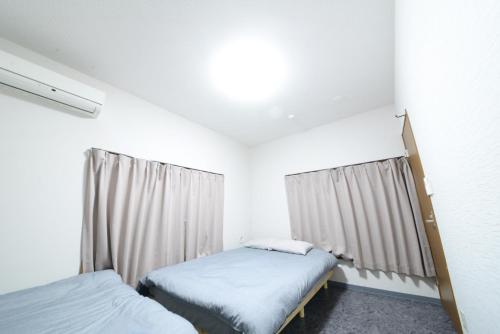 a bedroom with two beds and a window at NY Cottage B in Tokyo